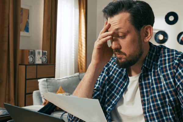Man stressed over debt paperwork at home