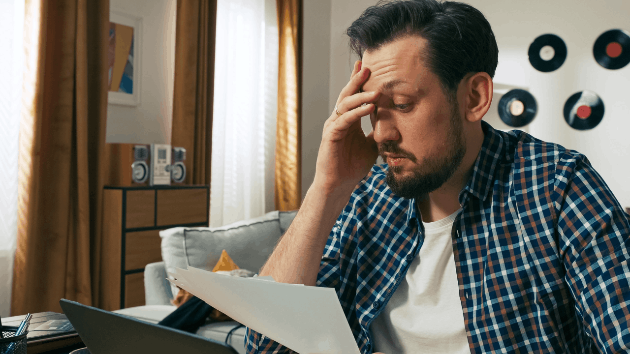 Man stressed over debt paperwork at home