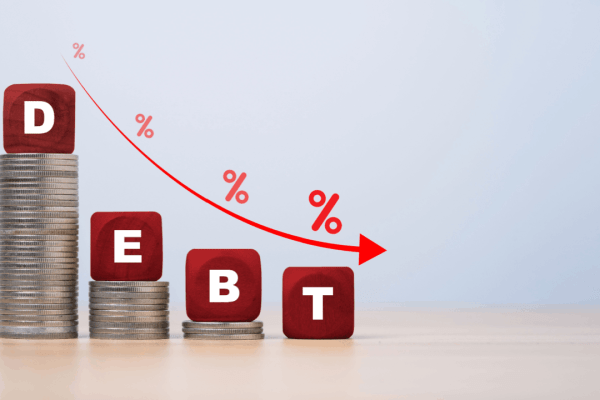 Red wooden blocks spelling DEBT on descending coin stacks showing what debts cannot be discharged in bankruptcy versus dischargeable obligations