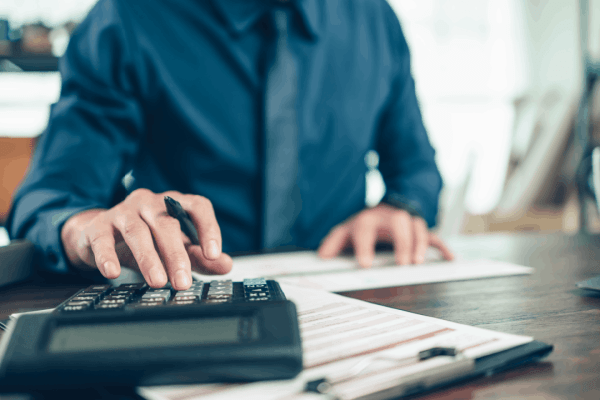 Man using calculator to review financial statements and assess medical debt credit report impact